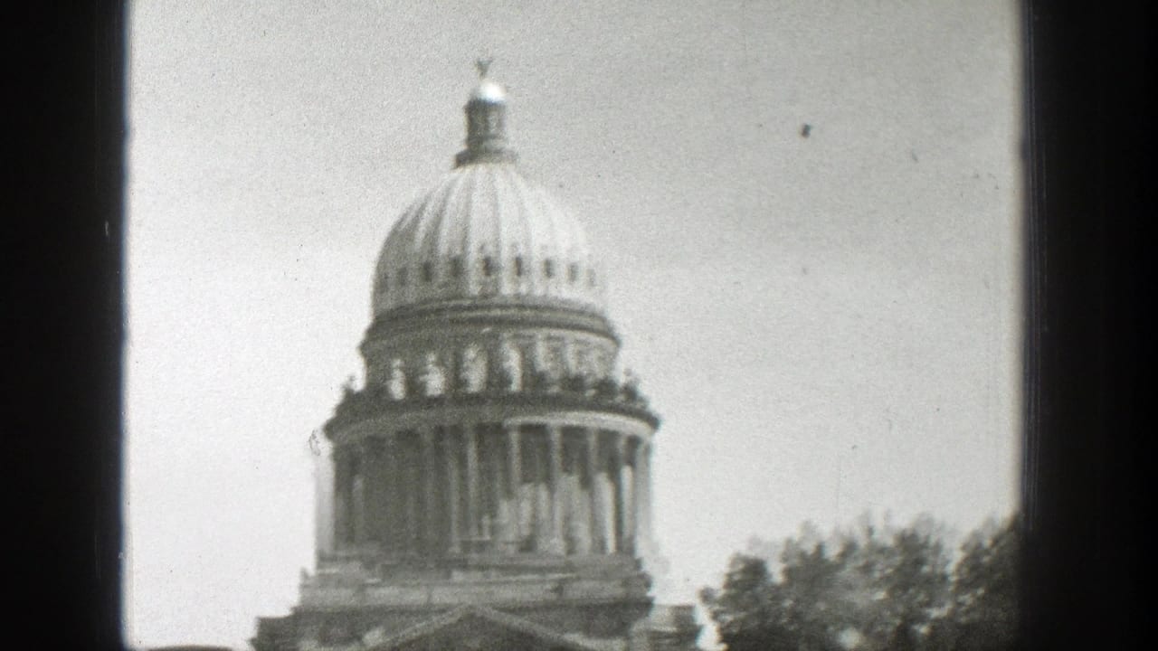 Domed classical building seen through dark film frame edges.