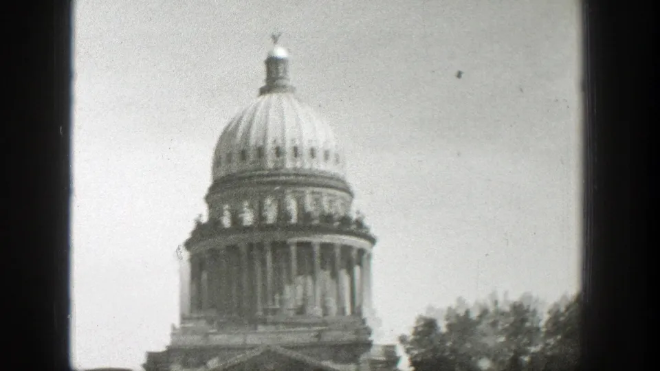 Likely Wyoming civic landmark with a large dome, filmed in soft black-and-white 8mm from a visitor viewpoint.