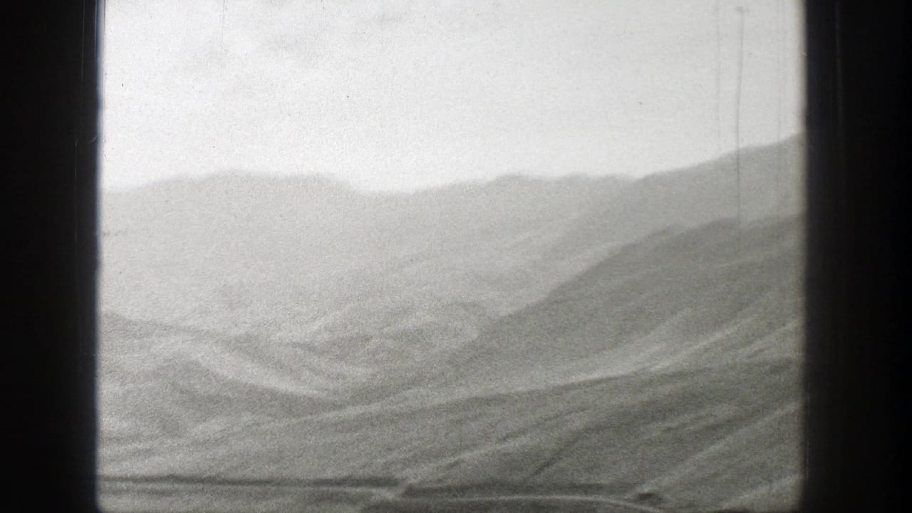 Wyoming mountain landscape in a soft 1939 8mm home-movie frame, with layered ridges and open terrain.