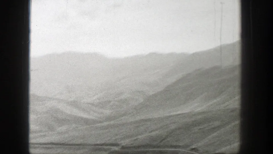 Wyoming mountain landscape in a soft 1939 8mm home-movie frame, with layered ridges and open terrain.