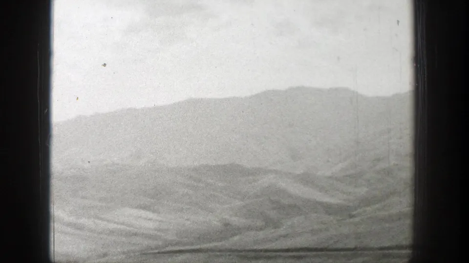 Distant Wyoming foothills and valley land appear in a faded 1939 8mm travel-film view with soft contrast.