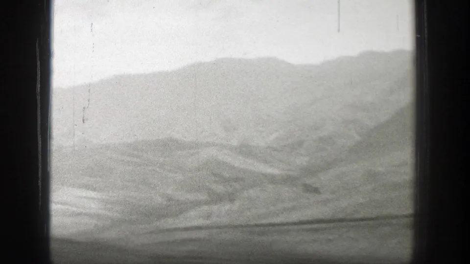 The final frame shows Wyoming hills and a hazy mountain ridge through a dark train-window frame in 1939 home-movie footage.