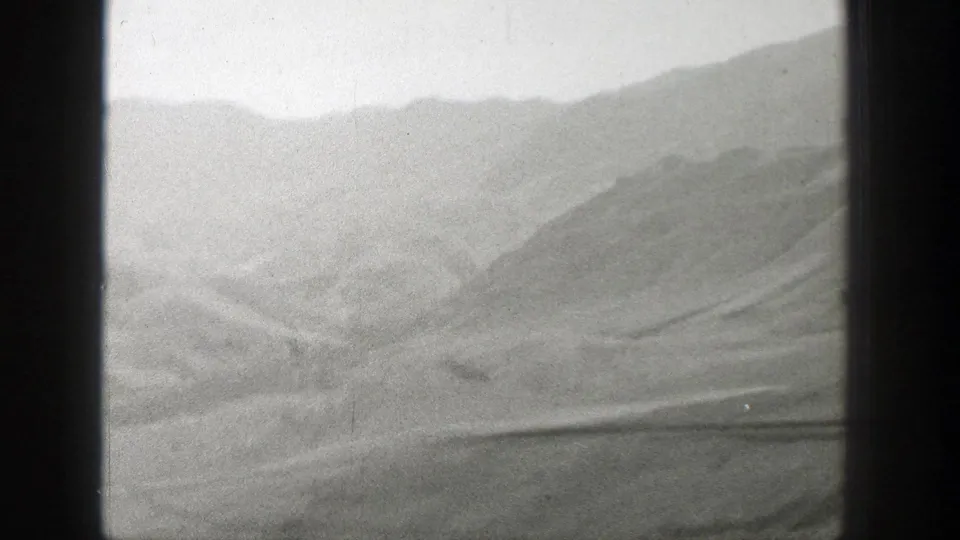 1939 Wyoming home-movie view of hazy mountain ridges and open desert framed by dark window mullions.