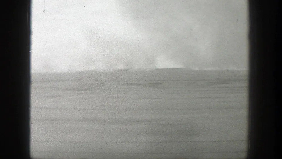1939 Wyoming home-movie frame showing a low horizon and cloudy sky viewed from a moving, dark-edged opening.