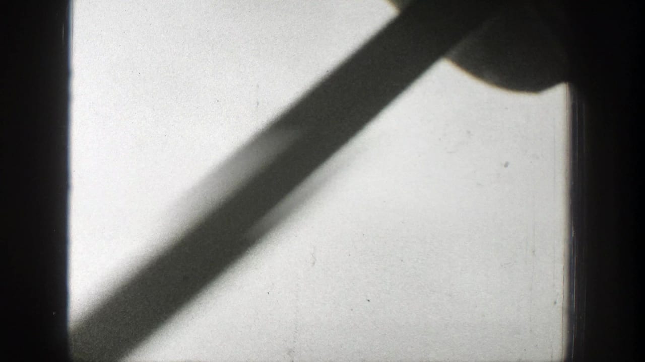 A static 1939 Wyoming 8mm view shows a dark frame bar and diagonal shadow crossing a bright smoke-hazed sky.