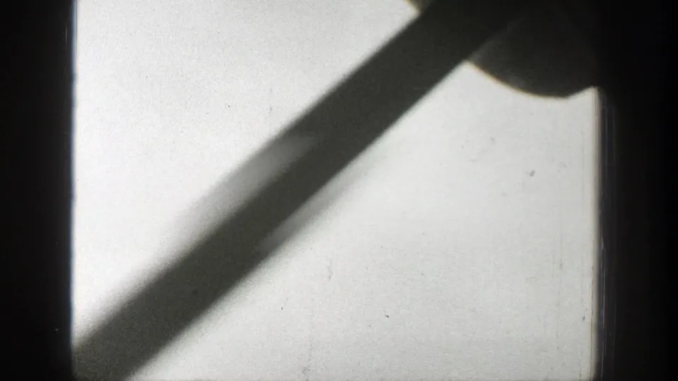 A static 1939 Wyoming 8mm view shows a dark frame bar and diagonal shadow crossing a bright smoke-hazed sky.
