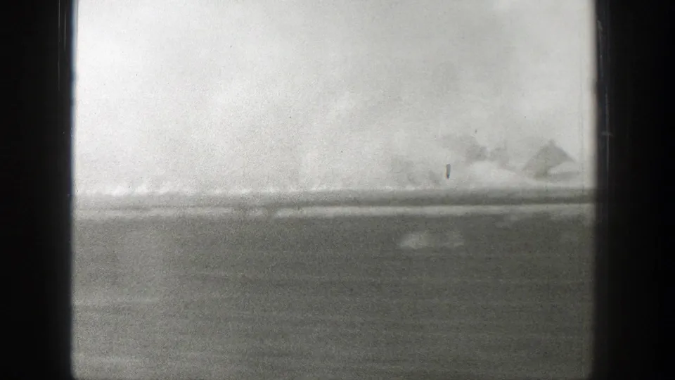 1939 Wyoming home-movie frame showing open terrain and a distant structure blurred by vehicle motion.