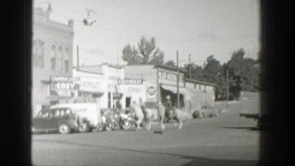 1939 Wyoming street view with horseback riders passing parked cars near COZY and CHEVROLET storefront signs.