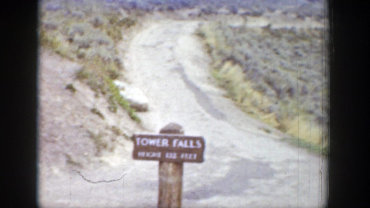 Wooden Tower Falls sign beside a dirt path on a scrubby slope.