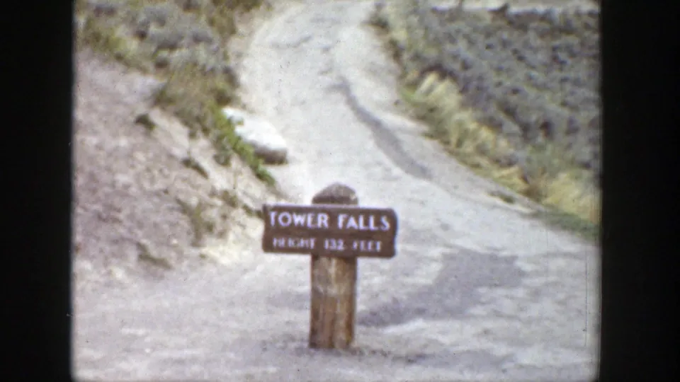 Tower Falls sign and dirt path in a late-1930s Wyoming home-movie view, with soft focus and faded color.