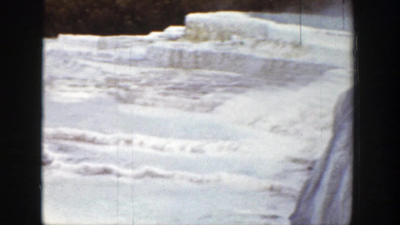 1939 Wyoming 8mm frame showing pale frozen terraces or mineral ledges bordered by dark winter trees.
