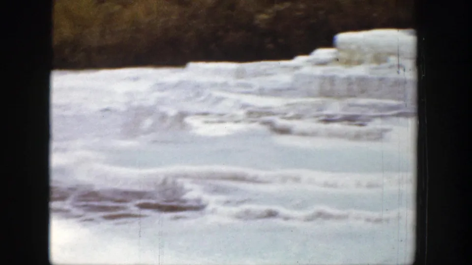 Soft 1939 Wyoming 8mm frame showing a panning view across snow, pale terraces, and dark trees.