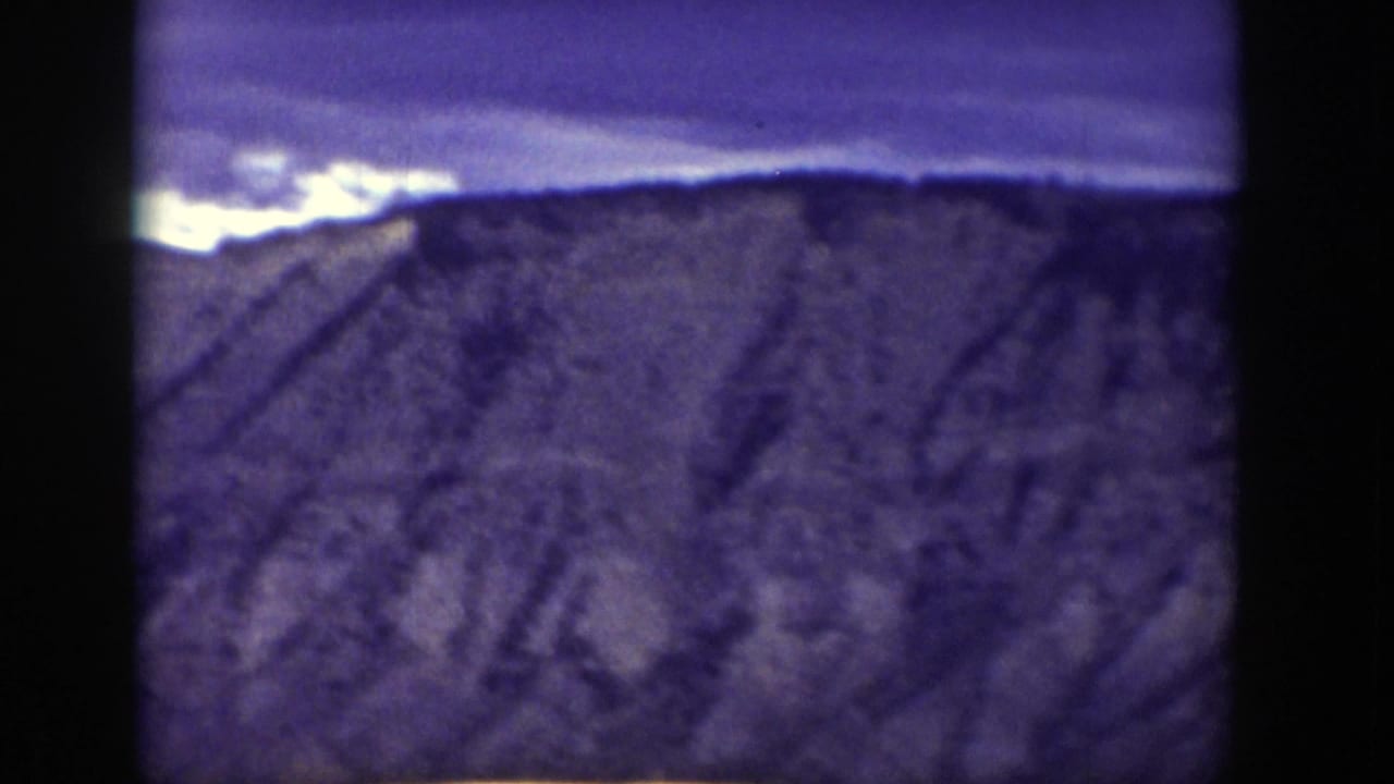 Early frame from the Wyoming 1939 home movie showing a distant mountain ridge under a dark sky, with the image soft and heavily shadowed.