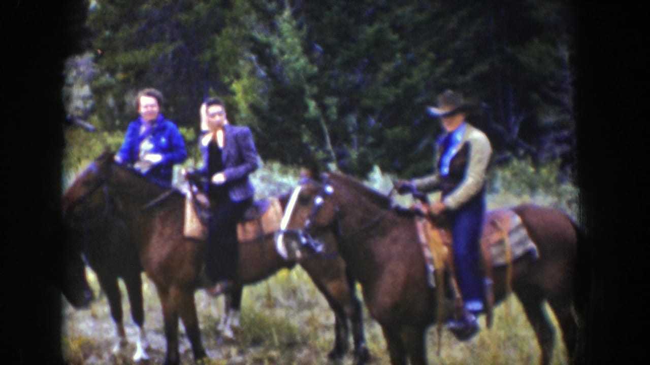 Three horseback riders in Wyoming mountain scenery face the camera, including two women and a man in a brimmed hat.