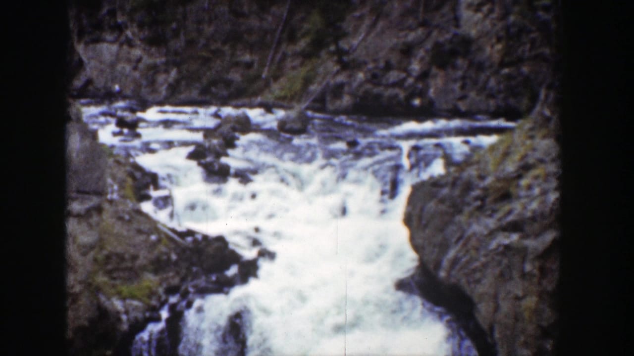 1939 Wyoming 8mm frame showing foamy water moving through a narrow brown-rock canyon under bright daylight.