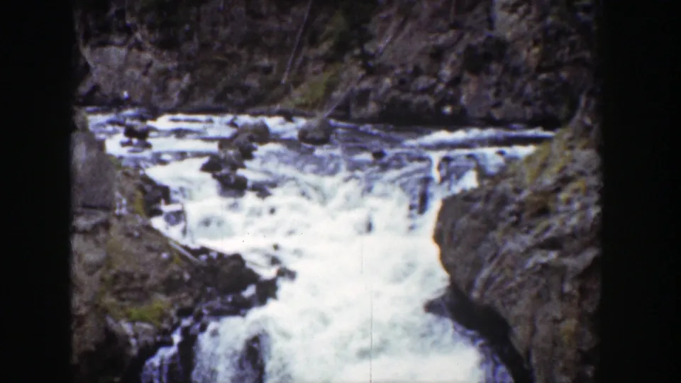 1939 Wyoming 8mm frame showing foamy water moving through a narrow brown-rock canyon under bright daylight.