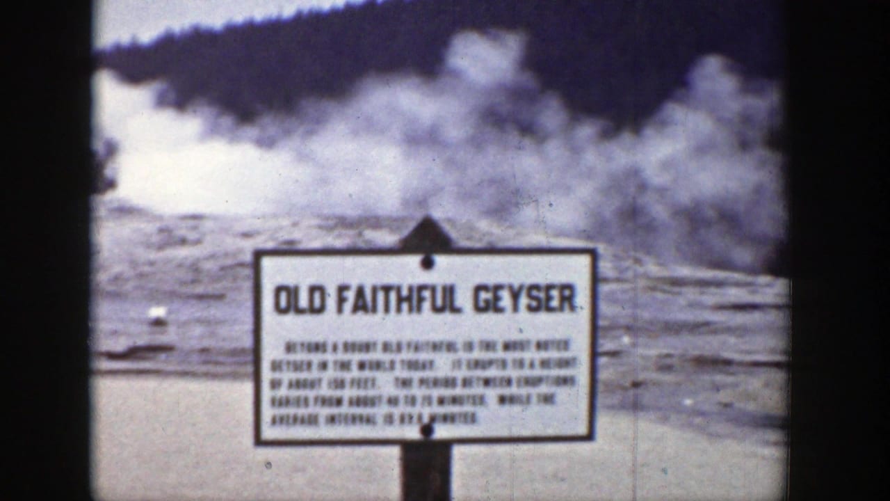 Old Faithful Geyser sign in front of steam rising from the geyser basin.