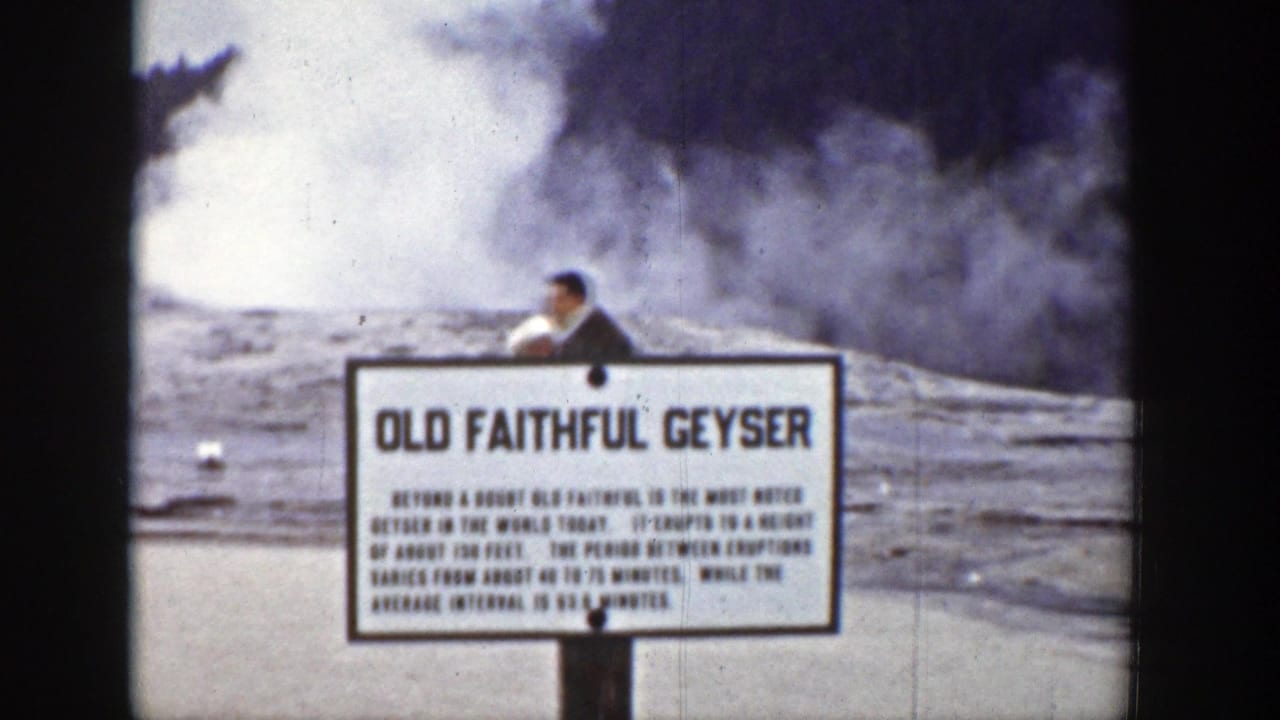 1939 Wyoming home-movie frame showing the Old Faithful Geyser sign, erupting steam, and a man near the viewing area.