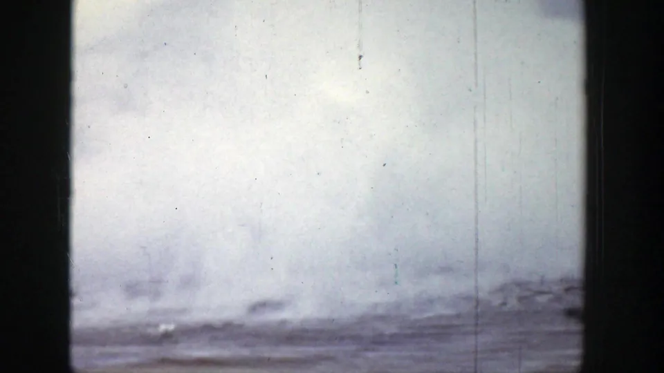 1939 Wyoming 8mm frame with smoke drifting over a low horizon and a pale, scratched film sky.