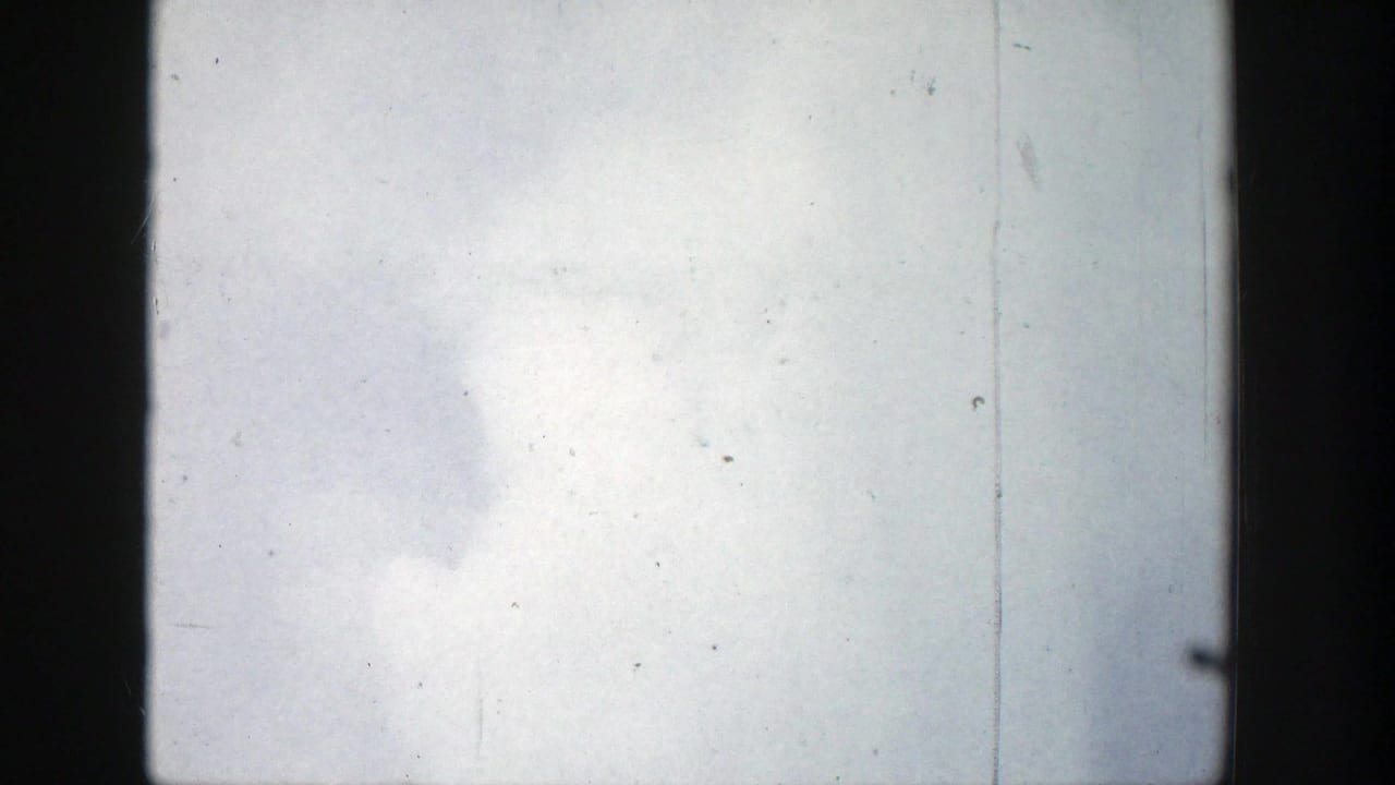White geyser vapor expands against a bright sky within dark film borders.