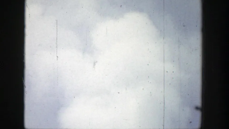 1939 Wyoming 8mm frame showing dense geyser steam or spray filling most of the view, with visible grain and vertical scratches.