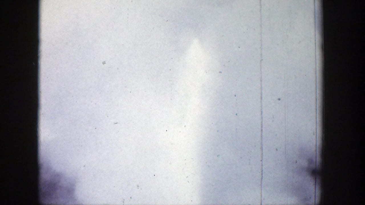 1939 Wyoming 8mm frame with a tall geyser plume and misty spray filling the right side of a bright sky.