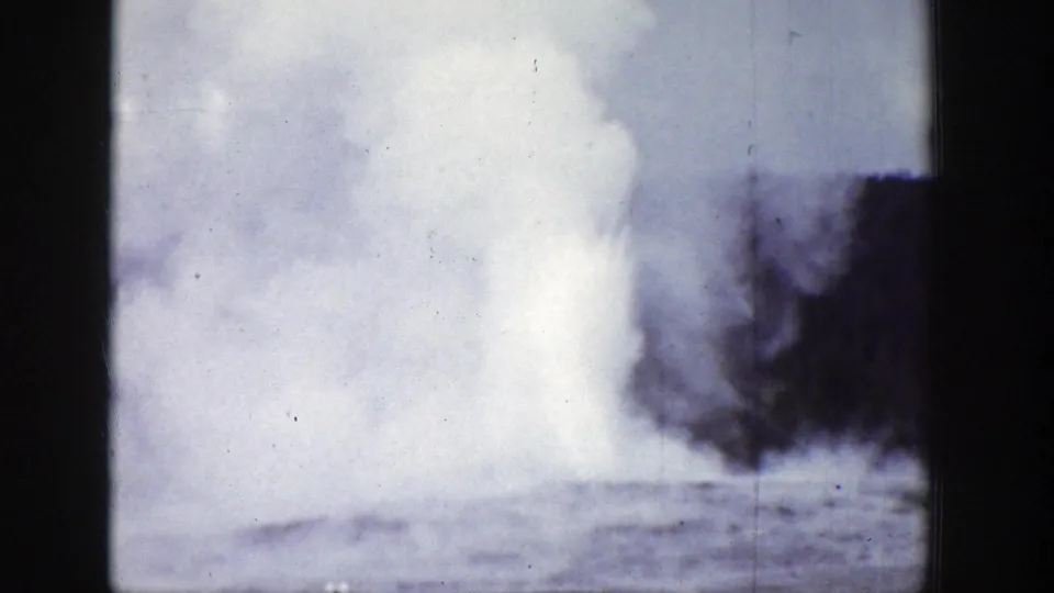 1939 Wyoming home-movie frame with drifting geyser steam, dark tree forms, and visible 8mm film texture.