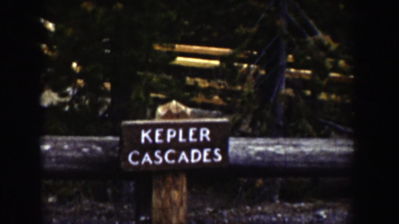 Wooden Kepler Cascades sign beside a log railing in a forest.