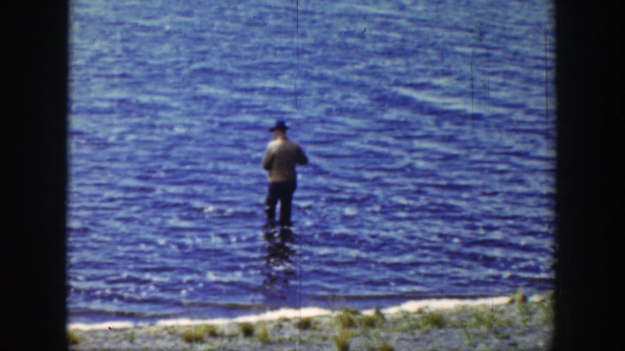 Adult man in a hat appears waist-deep in a Wyoming lake, seen from a 1939 8mm home-movie frame.