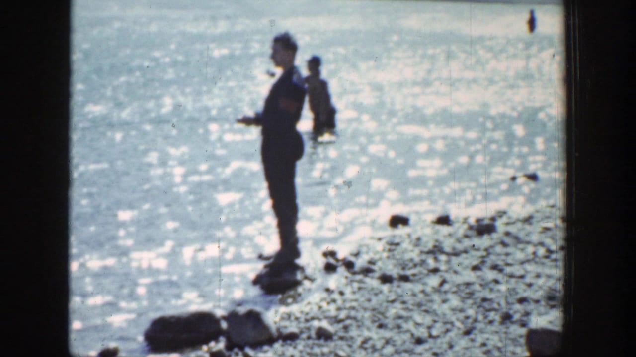 In Wyoming 1939 footage, one man stands near the rocky waterline while another wades in bright reflective water.