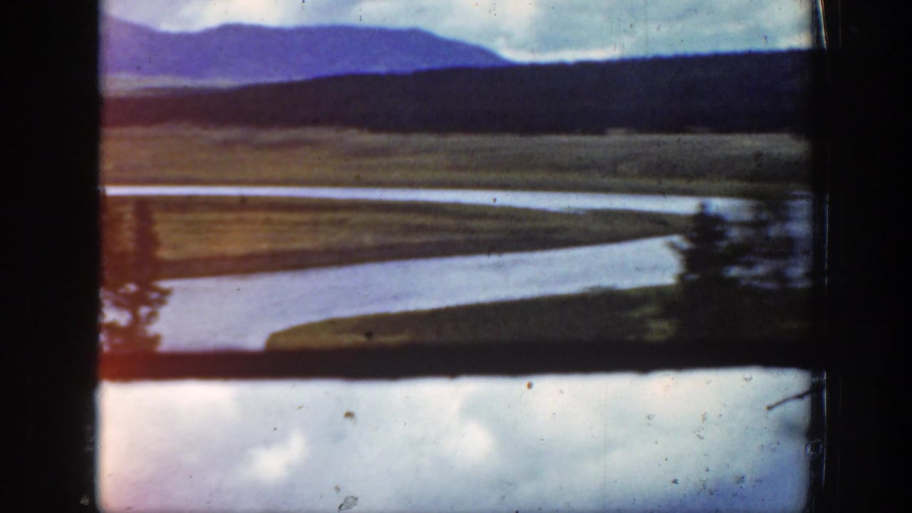 Wyoming 1939 home-movie frame showing a waterway or shoreline landscape through dark 8mm frame edges.