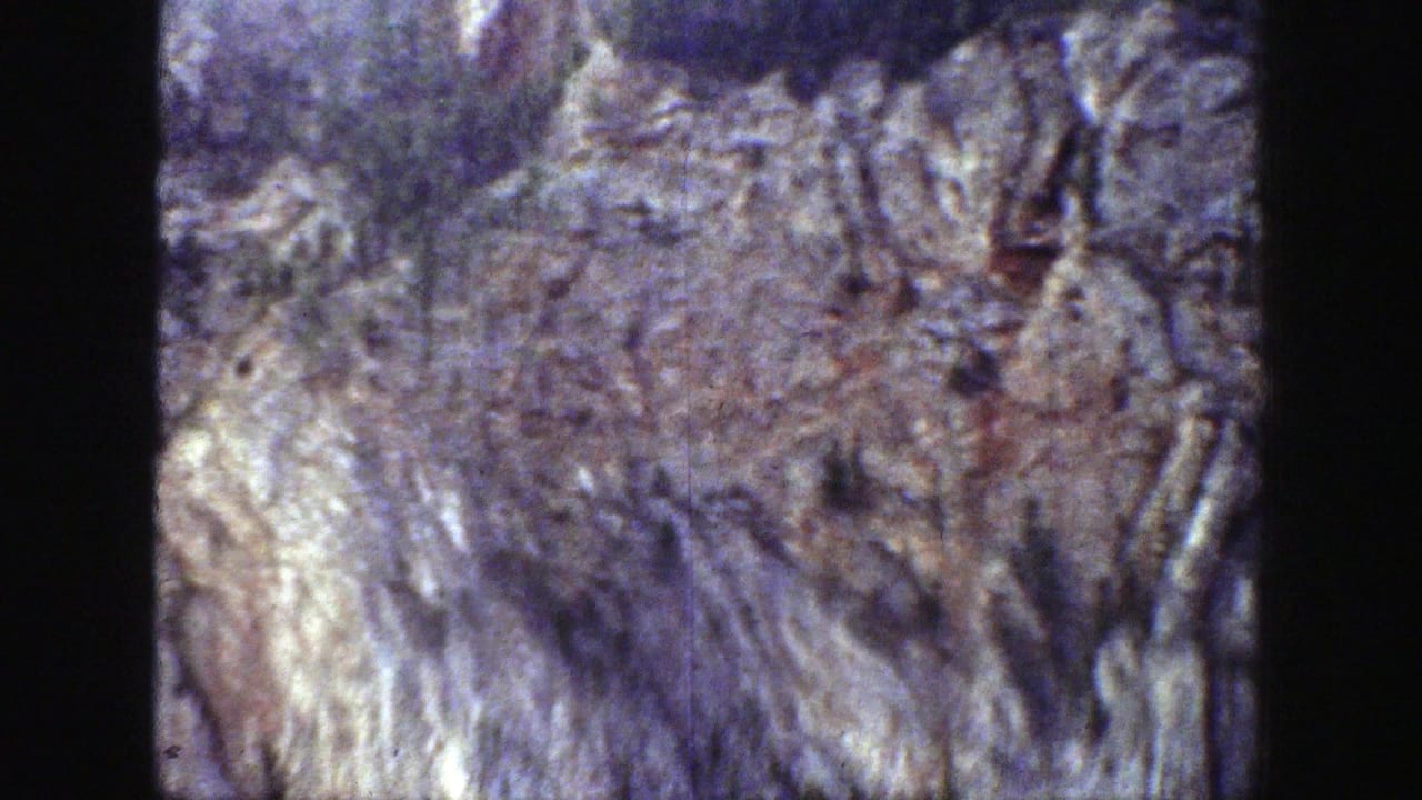 Wyoming rocky cliff and tree-lined ridge seen in 1939 8mm home-movie footage.