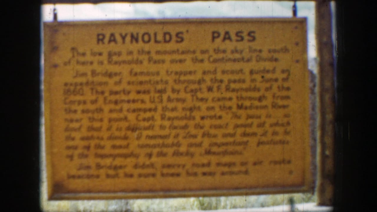 Slightly shifted close-up of the yellow Reynolds' Pass sign and its black text.