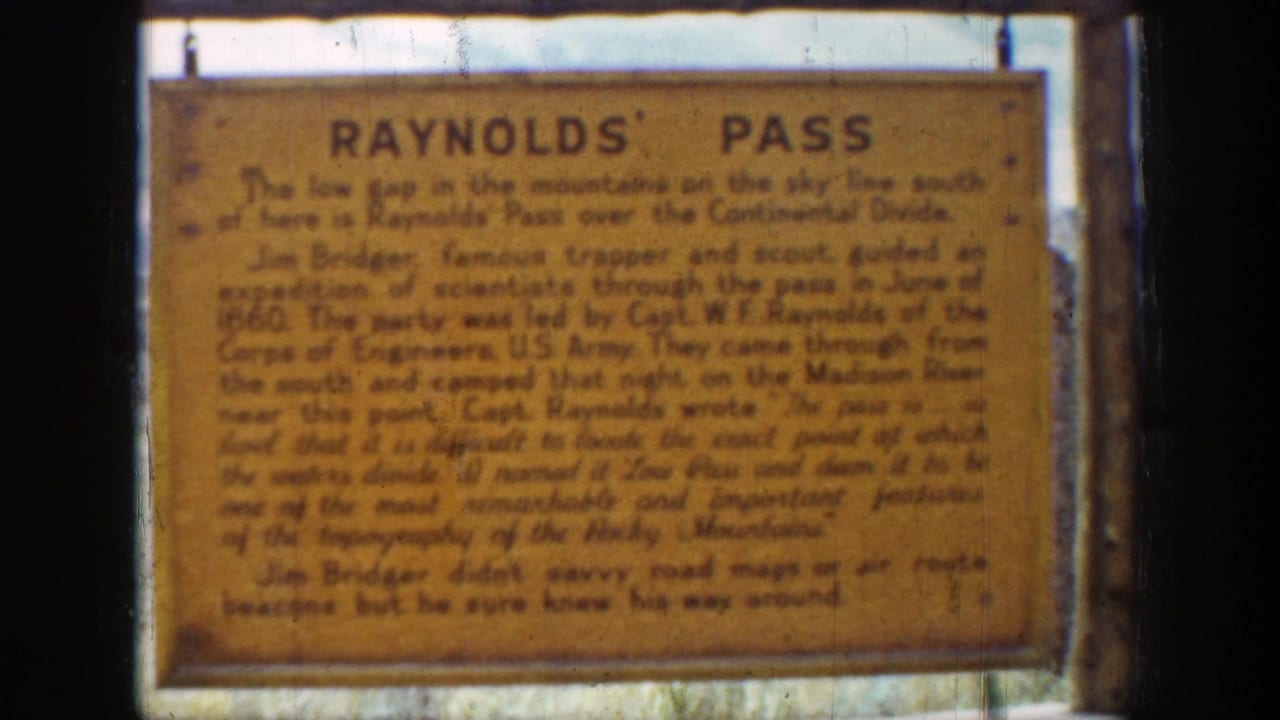 1939 Wyoming 8mm frame showing a close view of the Raynolds' Pass historical sign mounted outdoors.