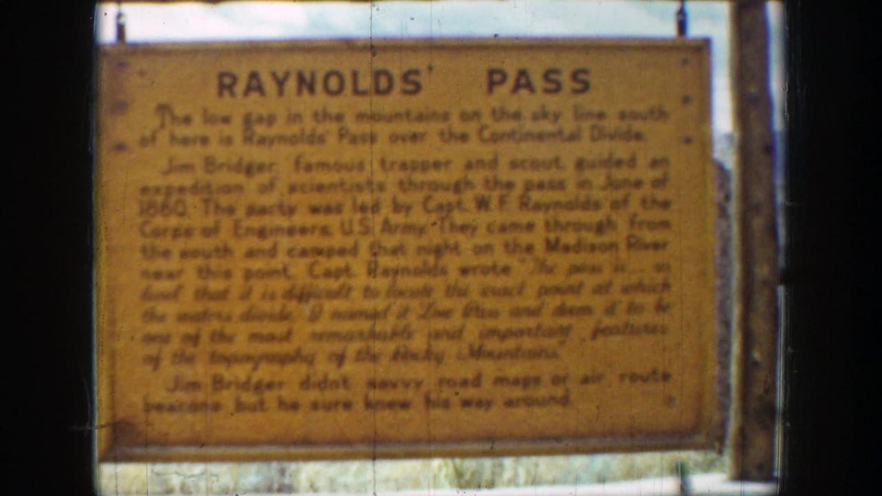 1939 Wyoming 8mm frame showing a close view of the Reynolds Pass historic sign with soft focus, fading color, and dark film borders.