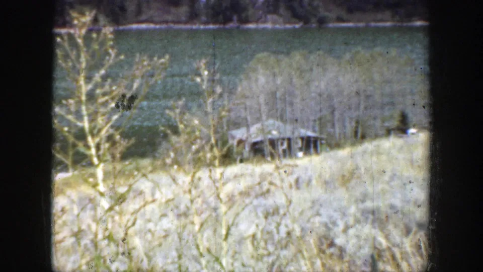 The lakeside view continues in Wyoming, 1939, with pale grass, shoreline trees, water, and a small dock-like structure below.