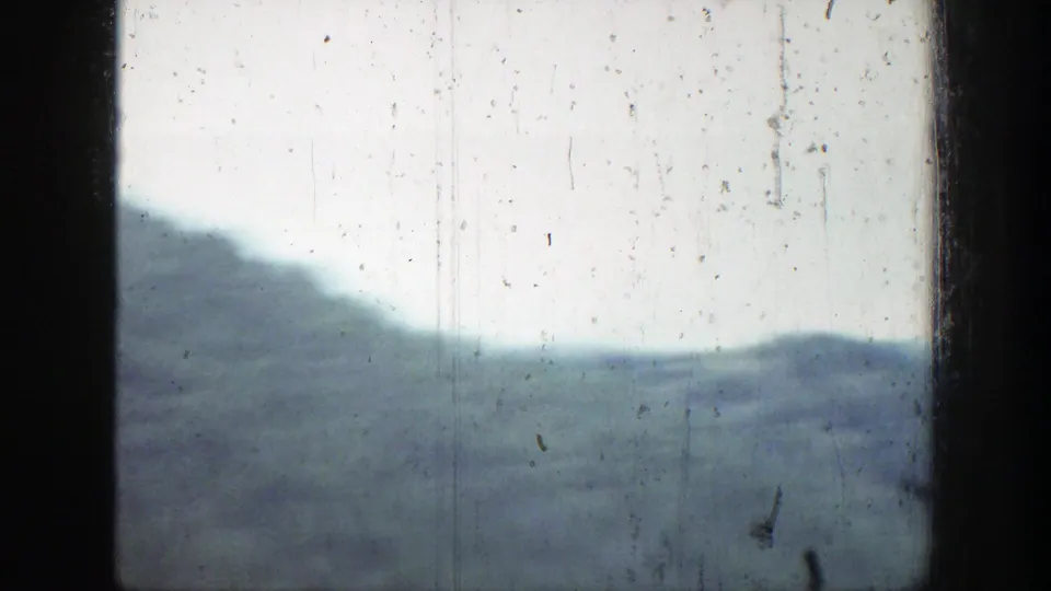 1939 Wyoming home-movie view of hazy hills and a mountain ridge, softened by exposure and film wear.