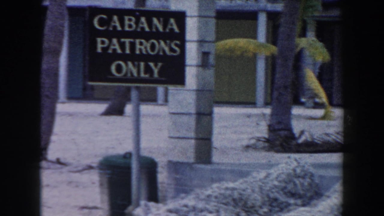 Cabana patrons only sign beside palm trees and resort columns.