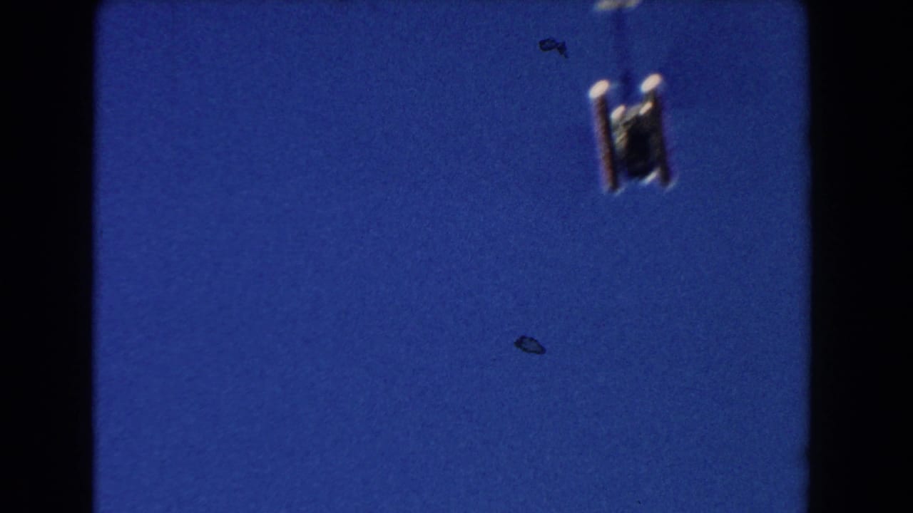 Helicopter underside near the top of a deep blue sky frame.