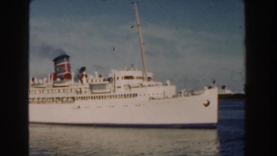 1960 Miami harbor footage shows a white passenger ship in profile, its painted funnel releasing dark smoke above the deck.