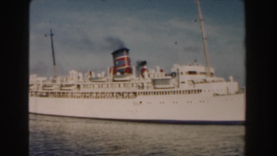 The 1960 Miami harbor shot continues with the white passenger ship filling the frame, smoke above the funnel and water below the hull.