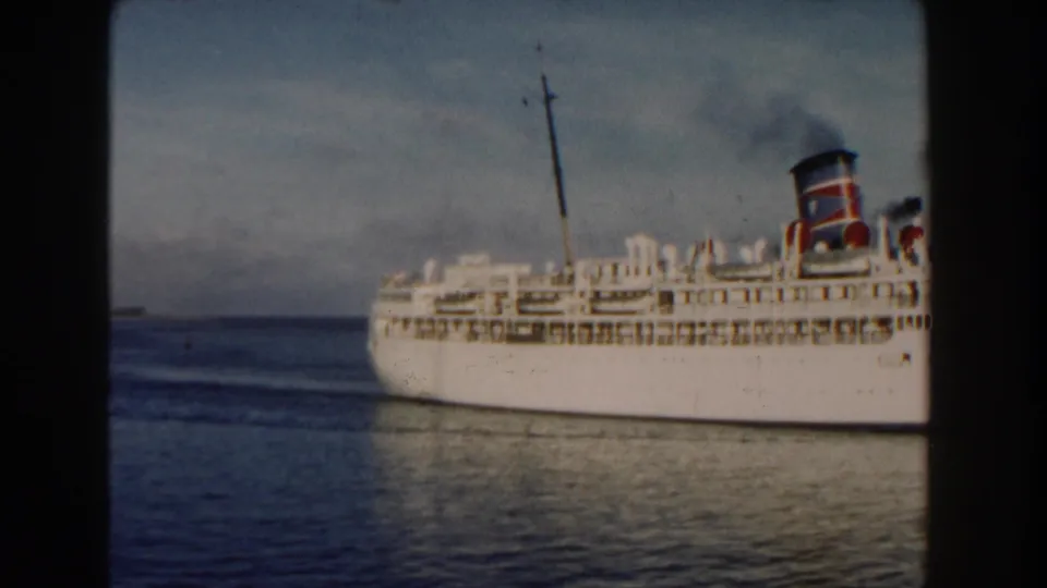 1960 Miami-area 8mm frame showing the ship farther across the water, partly cropped by the film frame.