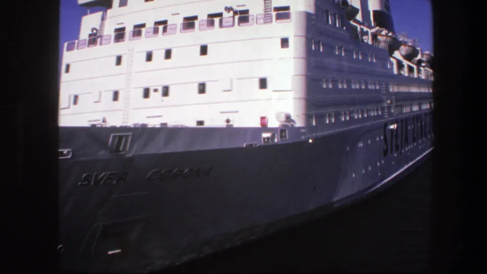 1975 Sweden 8mm frame showing the Svea Corona passenger ship docked in port, with white decks and hull lettering visible.
