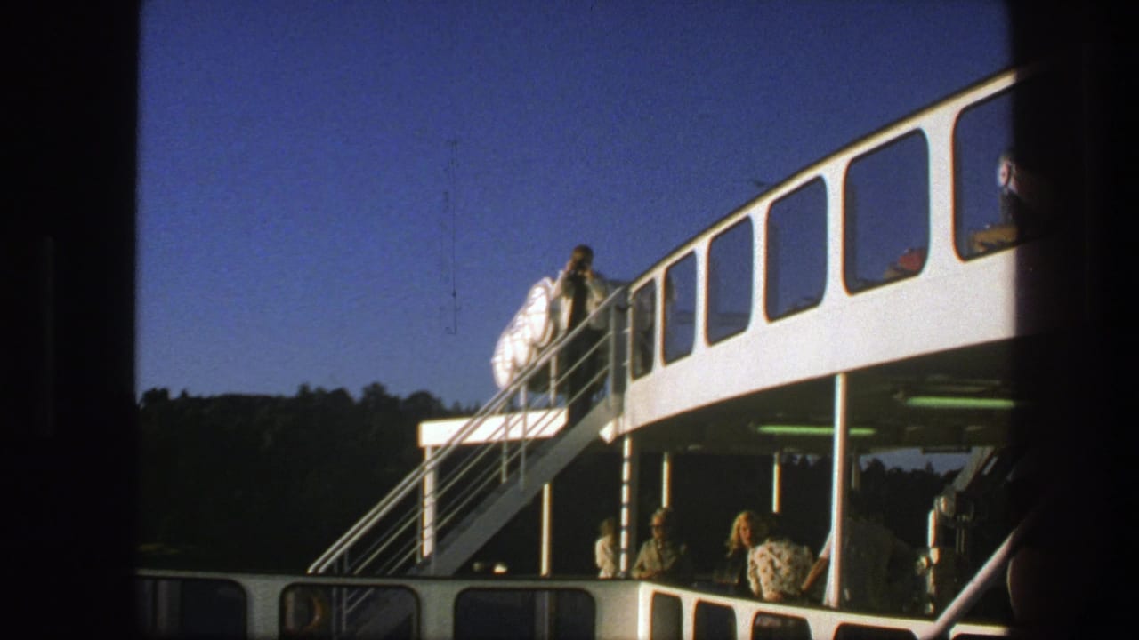 1975 Sweden ferry scene showing a man in a white shirt on the exterior stairs and passengers on the lower deck.