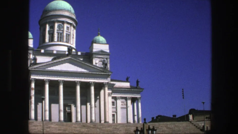 Cropped 8mm view of the columned facade and turquoise domes, with dark frame edges visible.
