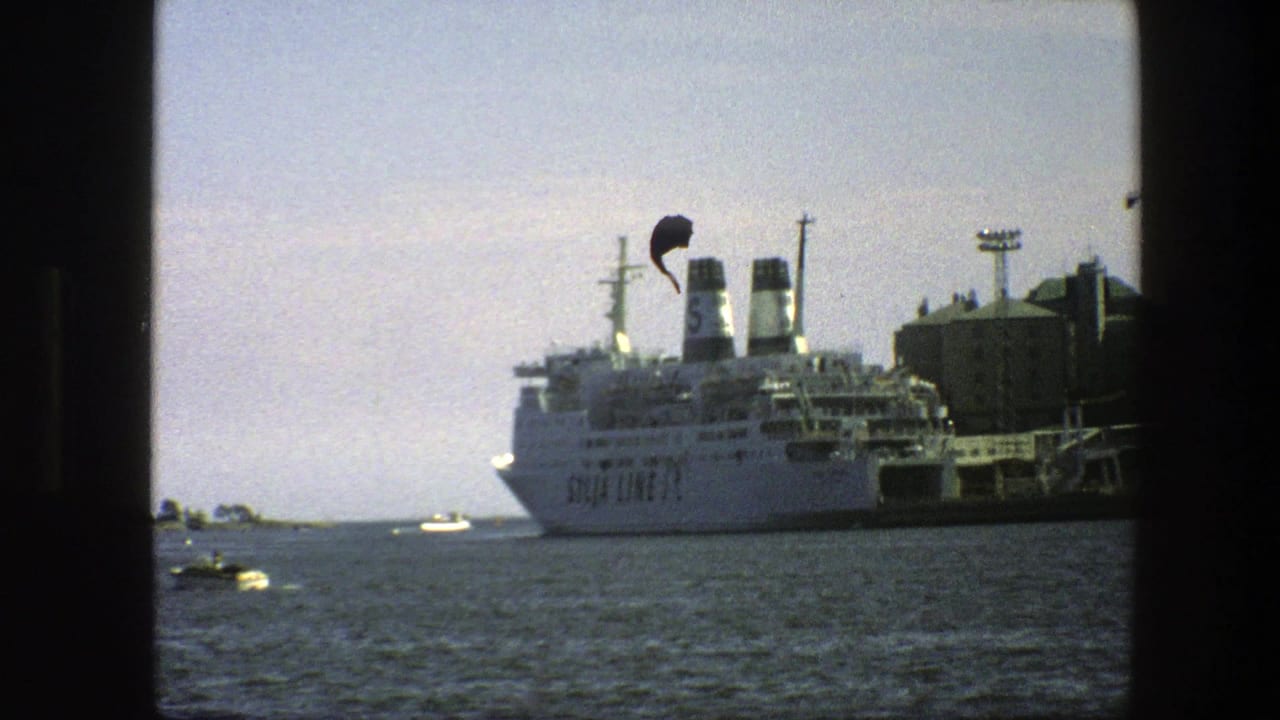 1975 Swedish port view of a large white ferry with twin funnels docked across the water, seen through dark frame edges.