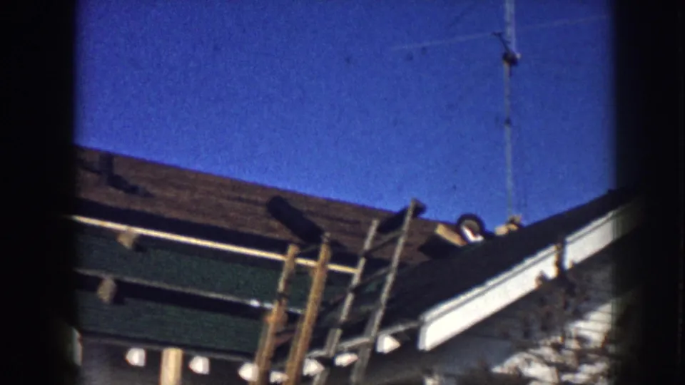 A 1958 Nebraska roof detail shows a ladder propped at the edge with a rooftop antenna above the shingles.