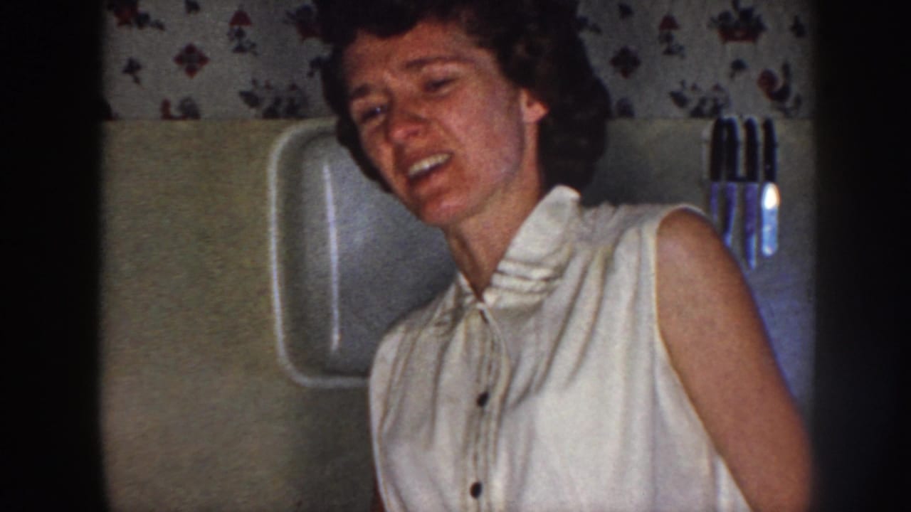 Woman smiling or laughing beside a bathroom wall and mounted fixture.