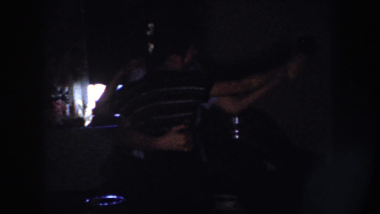 In Nebraska 1958 home-movie footage, a couple appears to dance in a dark room beside the glow of a television screen.