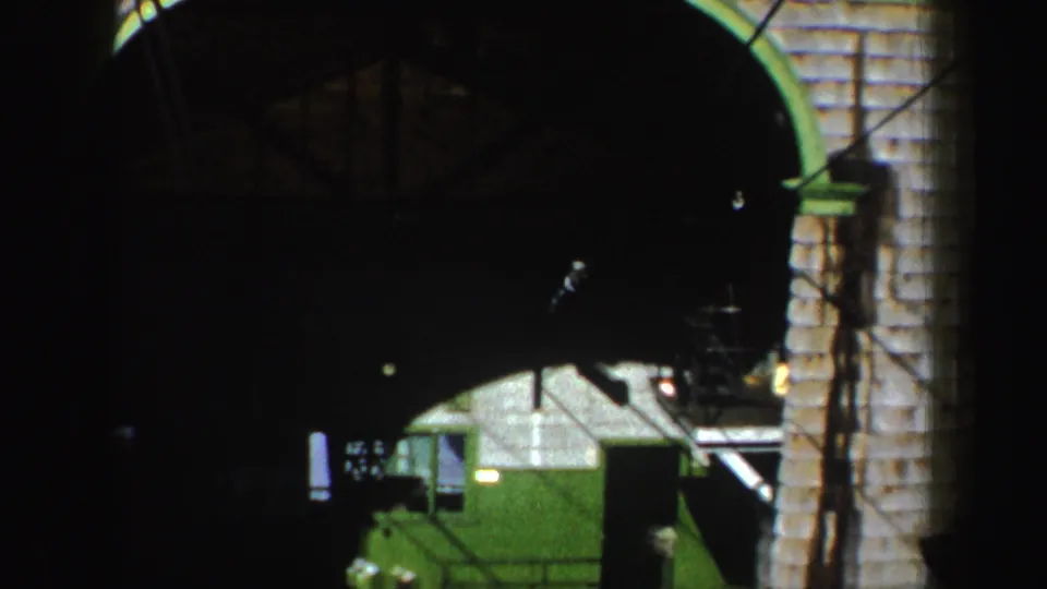 1962 New York frame showing green machine equipment under a dark arch, with stairs and a block wall at the right.